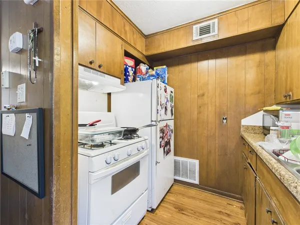 a kitchen with stainless steel appliances granite countertop a sink a stove and a refrigerator