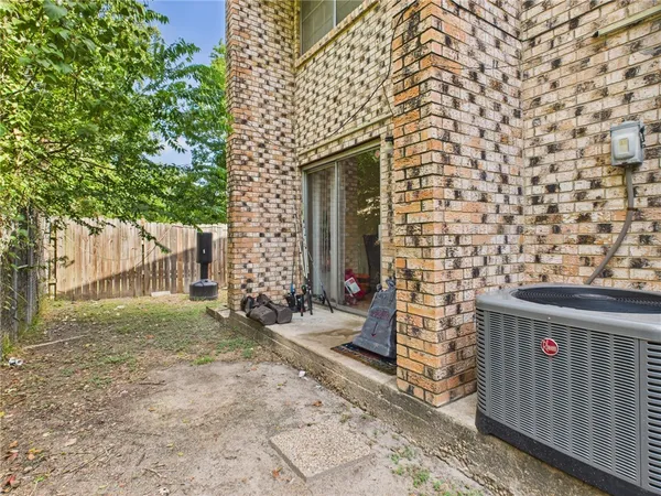 a brick building with a bench and trees
