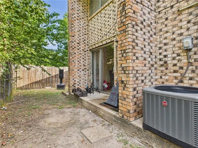 a brick building with a bench and trees