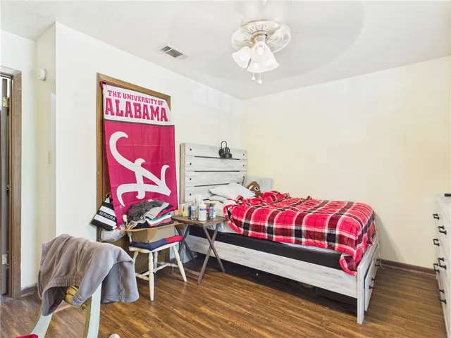 a bedroom with a bed and wooden floor