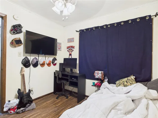 a bedroom with bed tv and a window