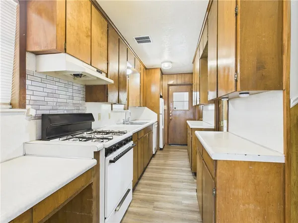 a kitchen with stainless steel appliances granite countertop a sink a stove and a refrigerator