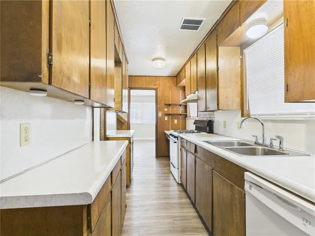 a kitchen with stainless steel appliances granite countertop a sink and a refrigerator
