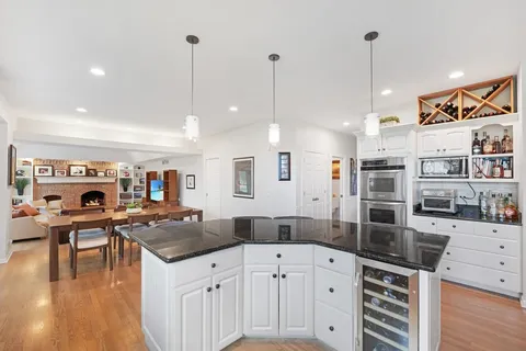 an open kitchen with white cabinets a sink and stainless steel appliances
