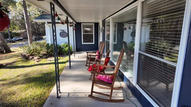a porch with a bench next to a yard