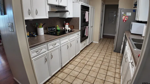 a kitchen with stainless steel appliances granite countertop a refrigerator and a stove top oven