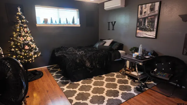 a bedroom with a bed and wooden floor