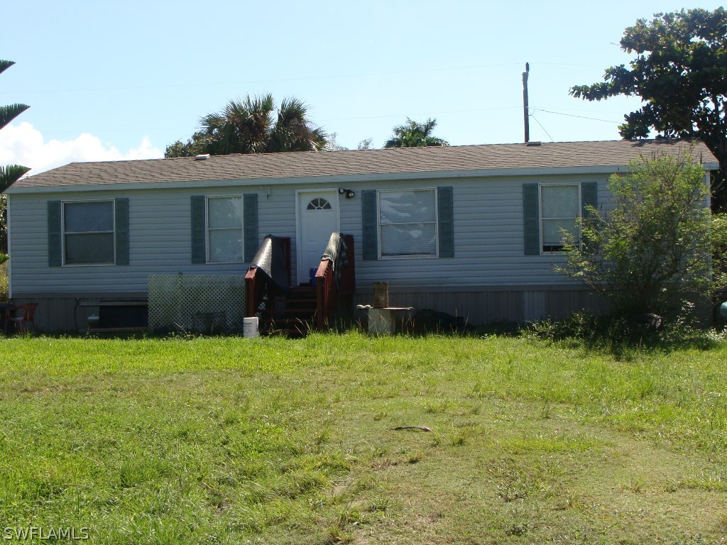 7421 Pinehurst Road Bokeelia, FL 33922 - Photo 1 of 21 a backyard of a house with wooden fence and large trees