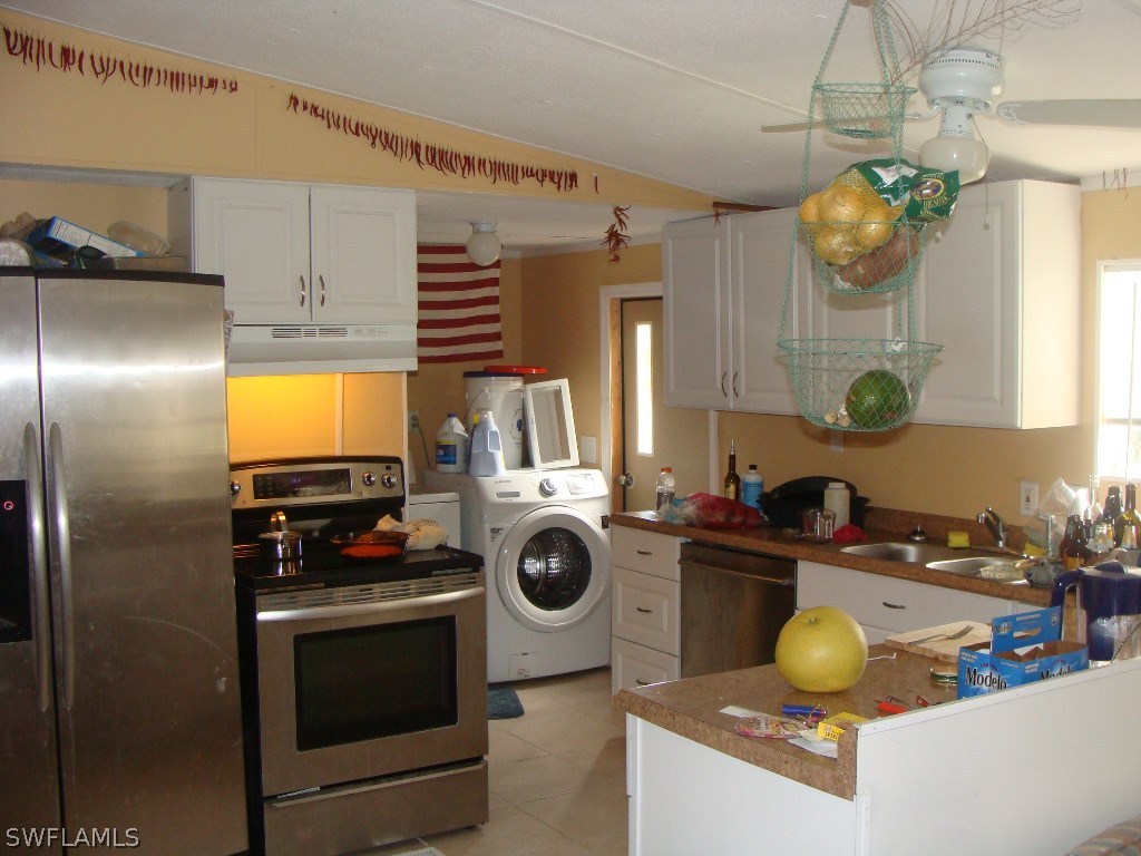 7421 Pinehurst Road Bokeelia, FL 33922 - Photo 11 of 21 a kitchen with stainless steel appliances granite countertop a sink a stove and cabinets