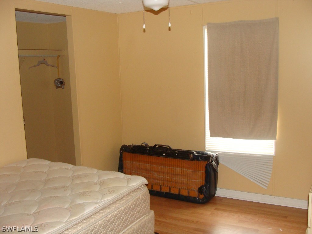 7421 Pinehurst Road Bokeelia, FL 33922 - Photo 14 of 21 a room with a bed and wooden floor