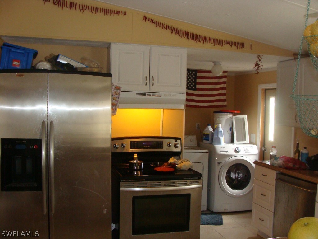 7421 Pinehurst Road Bokeelia, FL 33922 - Photo 10 of 21 a kitchen with a refrigerator and washer