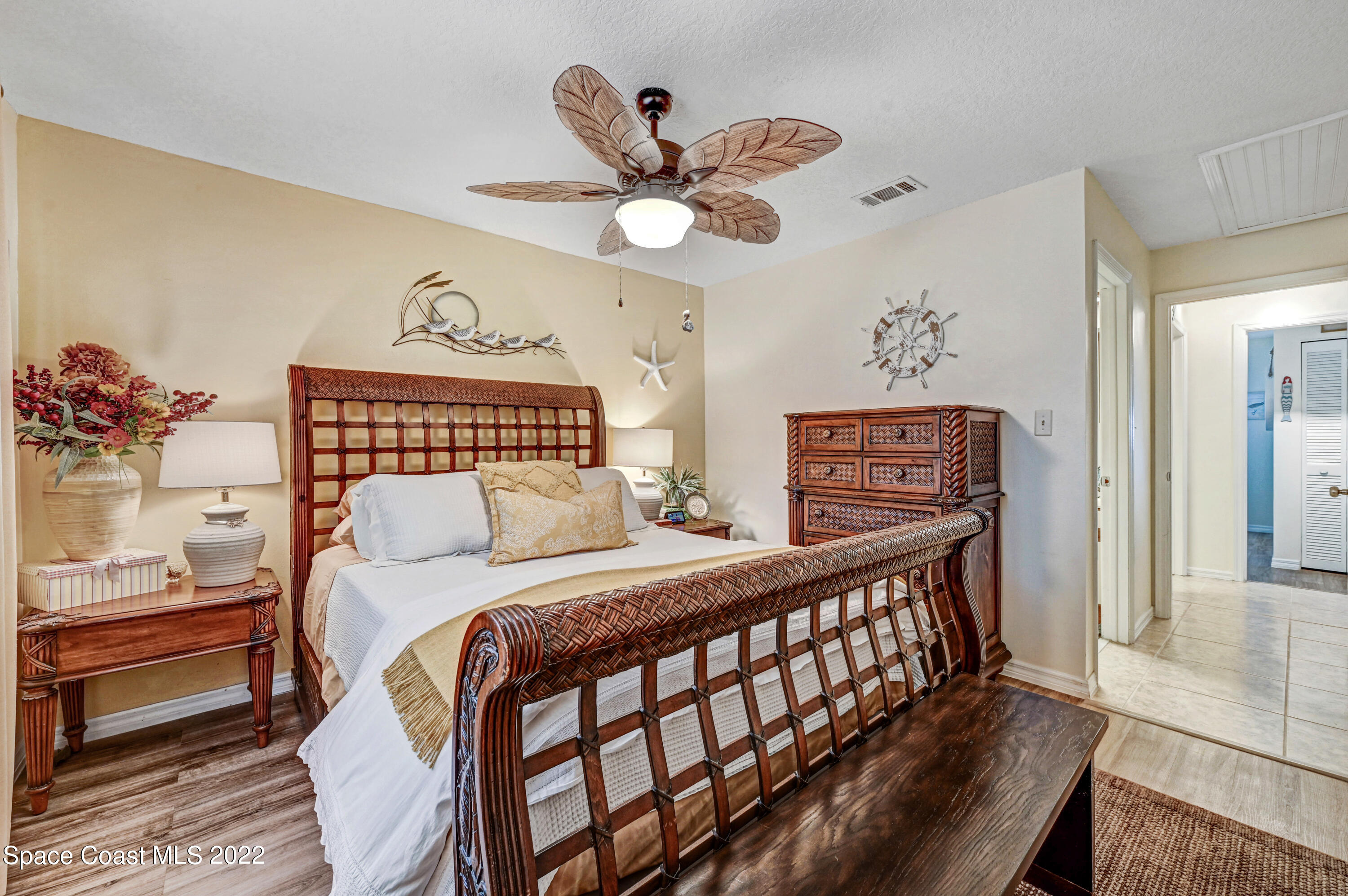 2929 Kirkland Road Northeast Palm Bay, FL 32905 - Photo 19 of 32 a bedroom with a bed and a chandelier