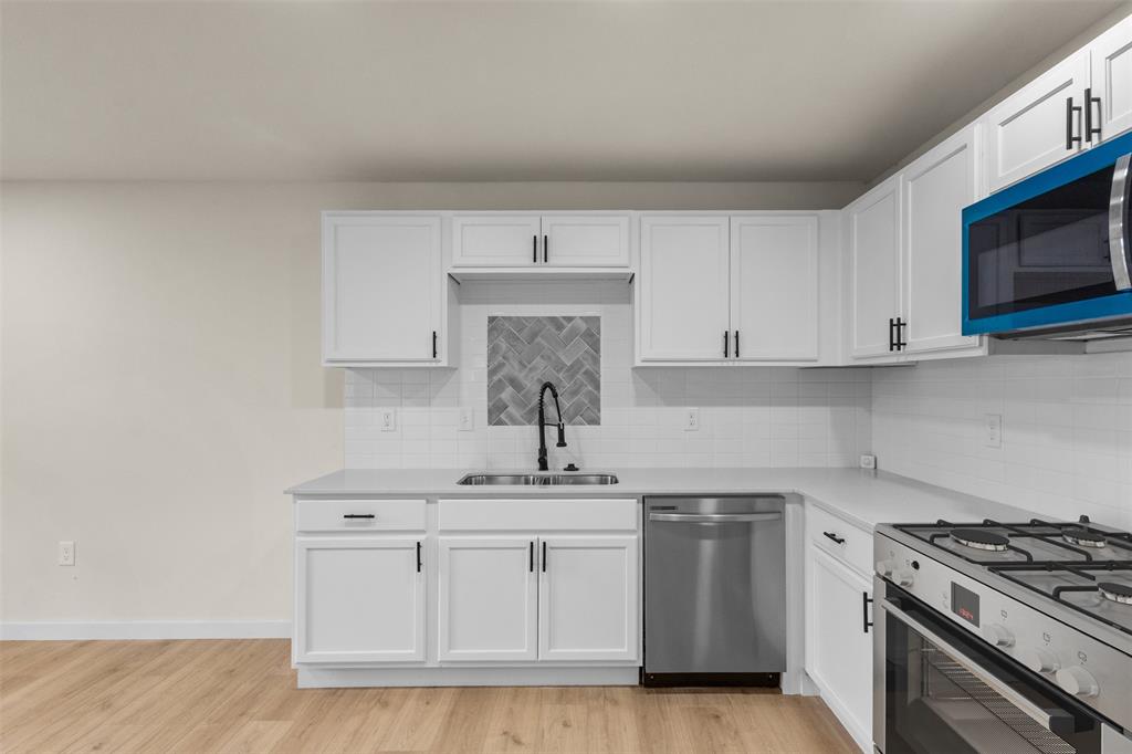 3915 Coolidge Street Dallas, TX 75215 - Photo 13 of 33 a kitchen with white cabinets stainless steel appliances and sink