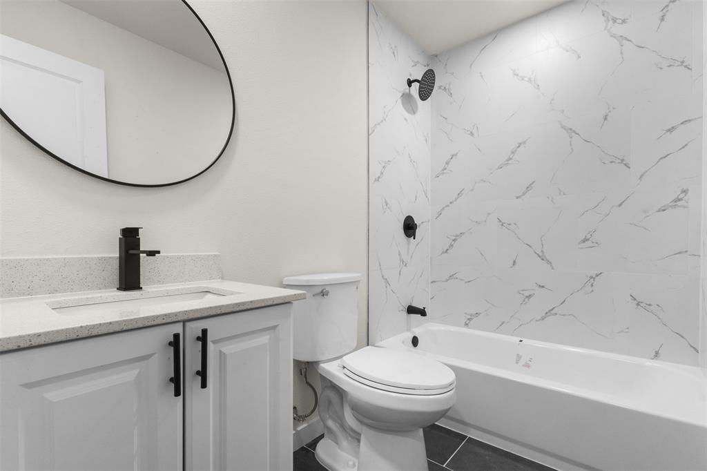 3915 Coolidge Street Dallas, TX 75215 - Photo 19 of 33 a bathroom with a sink a toilet and a mirror