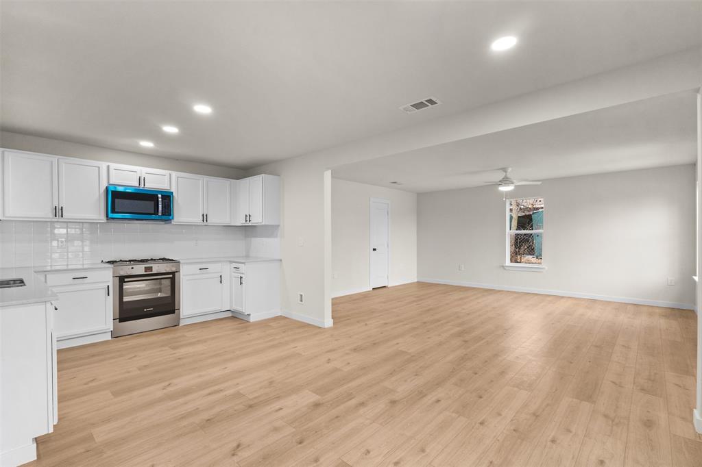 3915 Coolidge Street Dallas, TX 75215 - Photo 10 of 33 a large kitchen with stainless steel appliances granite countertop a stove a sink dishwasher and a oven with white cabinets