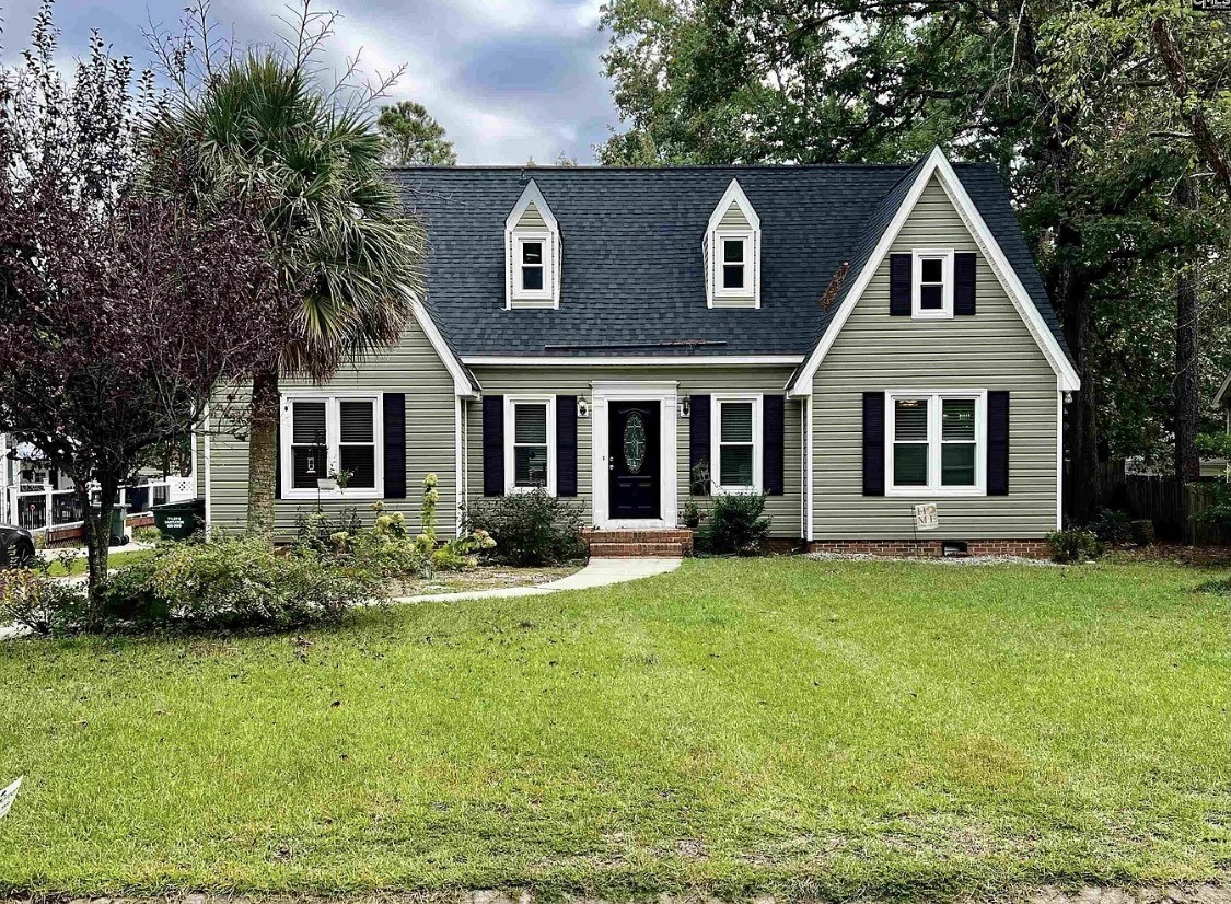 a front view of a house with a yard and trees
