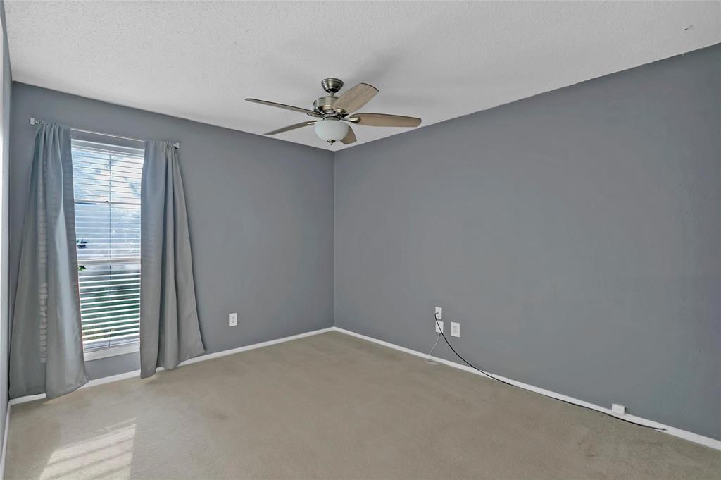 6104 Kelly Elliott Road Arlington, TX 76001 - Photo 10 of 25 an empty room with a window and ceiling fan