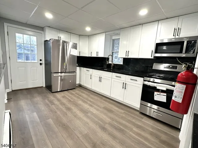 a kitchen with stainless steel appliances a refrigerator microwave and sink