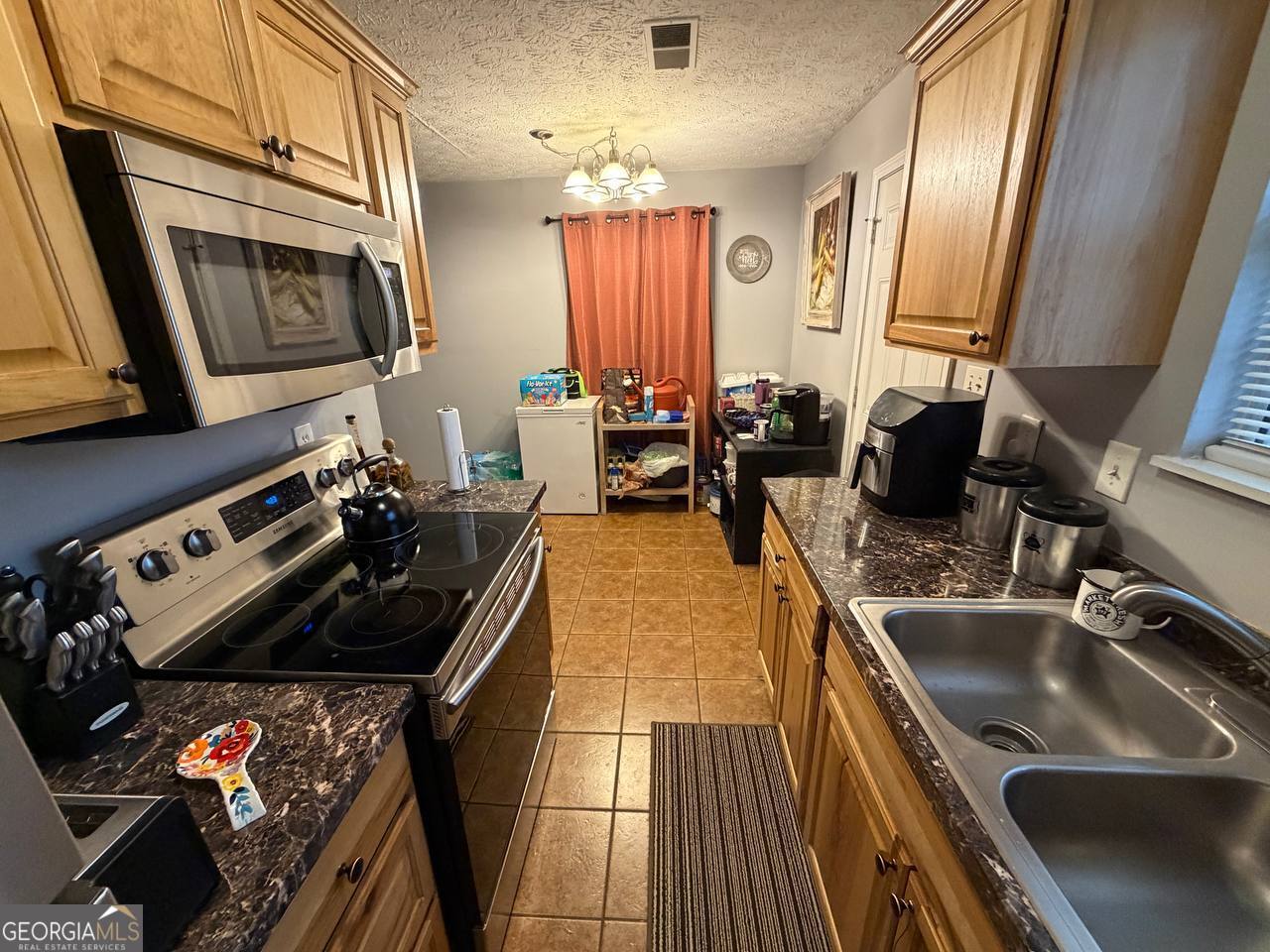 1137 Reed Place Monroe, GA 30655 - Photo 4 of 10 a kitchen with a sink stove and microwave