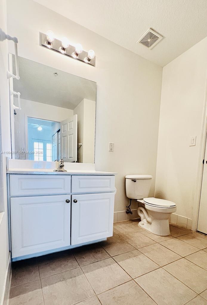 1209 Main Street, Unit 315 Jupiter, FL 33458 - Photo 14 of 18 a bathroom with a toilet sink and mirror