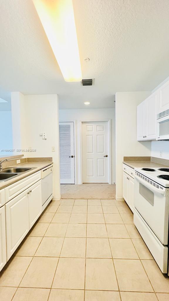 1209 Main Street, Unit 315 Jupiter, FL 33458 - Photo 10 of 18 a kitchen with a stove a sink and a refrigerator