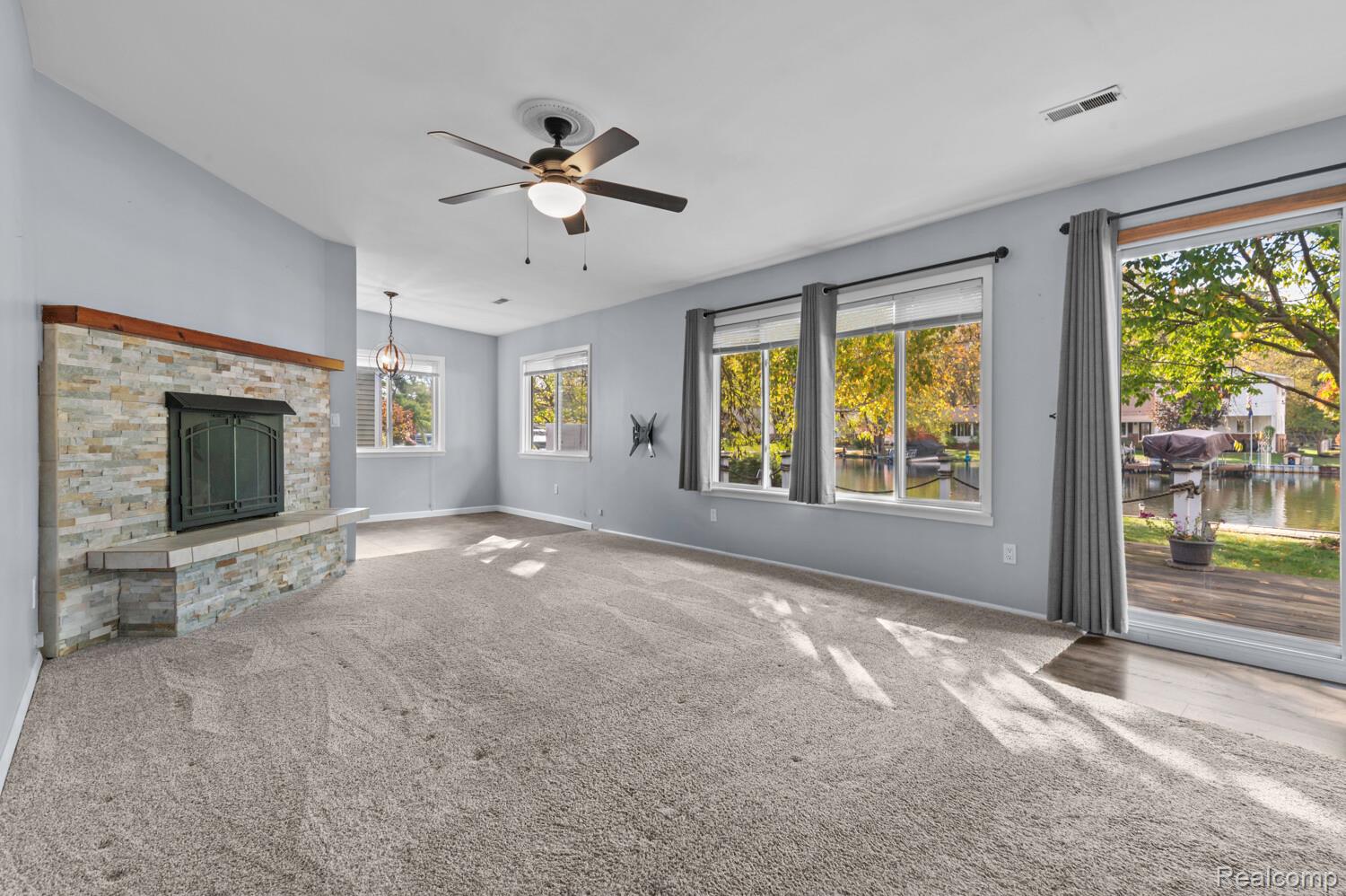 11026 Colony Pinckney, MI 48169 - Photo 23 of 40 Unfurnished living room with a ceiling fan, a fireplace, and carpet floors
