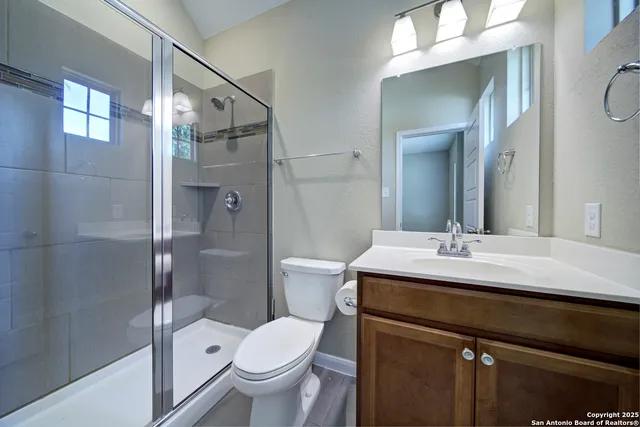 a bathroom with a sink mirror and a shower