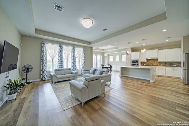 a living room with furniture a flat screen tv and a large window