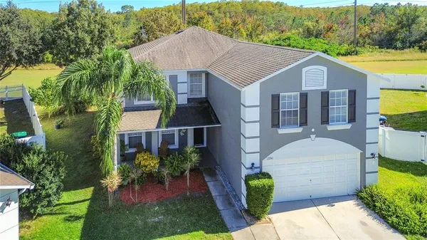 a aerial view of a house next to a big yard and potted plants