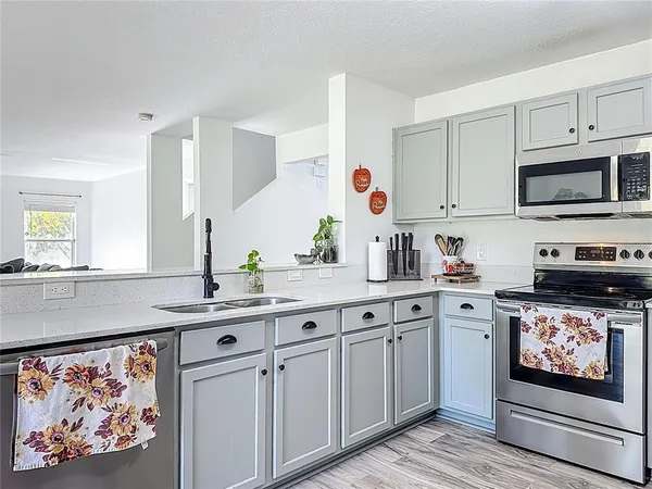 a kitchen with stainless steel appliances a refrigerator sink and cabinets