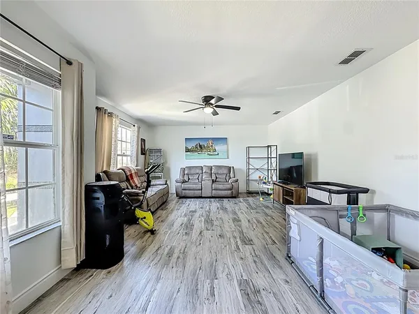 a living room with furniture and a ceiling fan