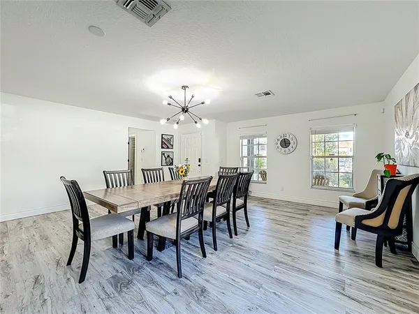 a kitchen with stainless steel appliances granite countertop a stove top oven a sink dishwasher and a microwave oven on the wooden floor