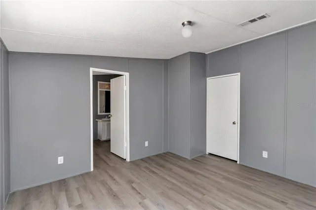 a view of an empty room with closet and a window