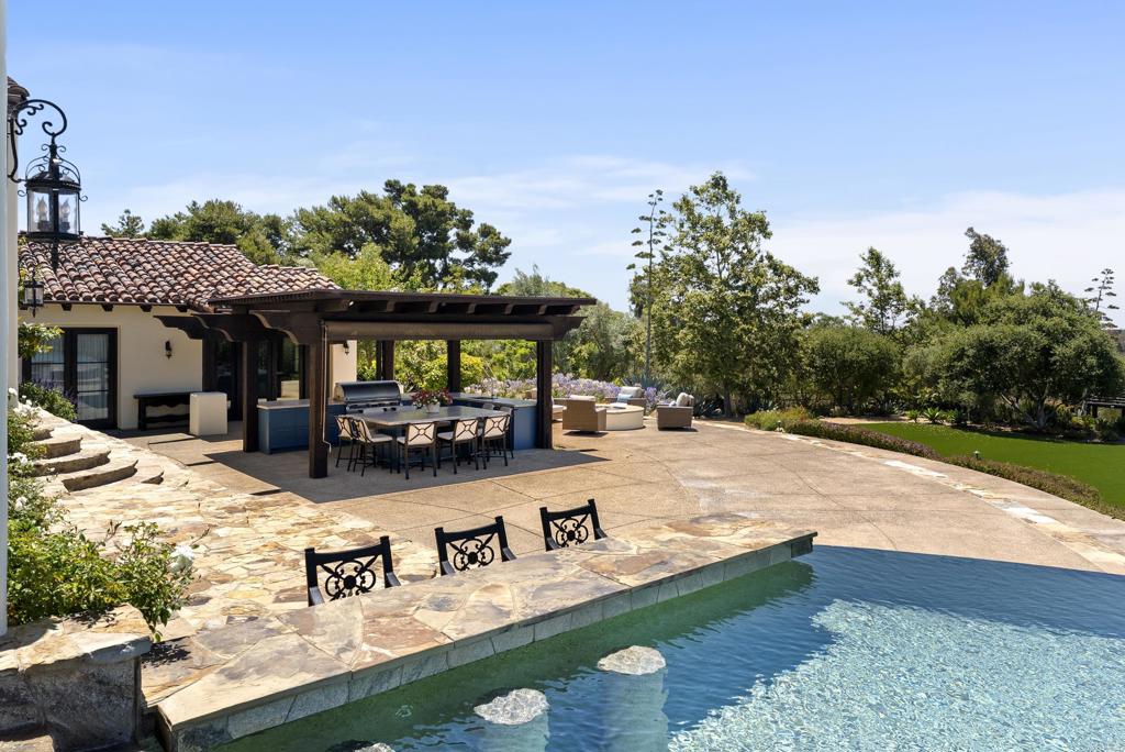 5293 La Glorieta Rancho Santa Fe, CA 92067 - Photo 16 of 25 a view of a house with floor to ceiling windows and a table and chairs