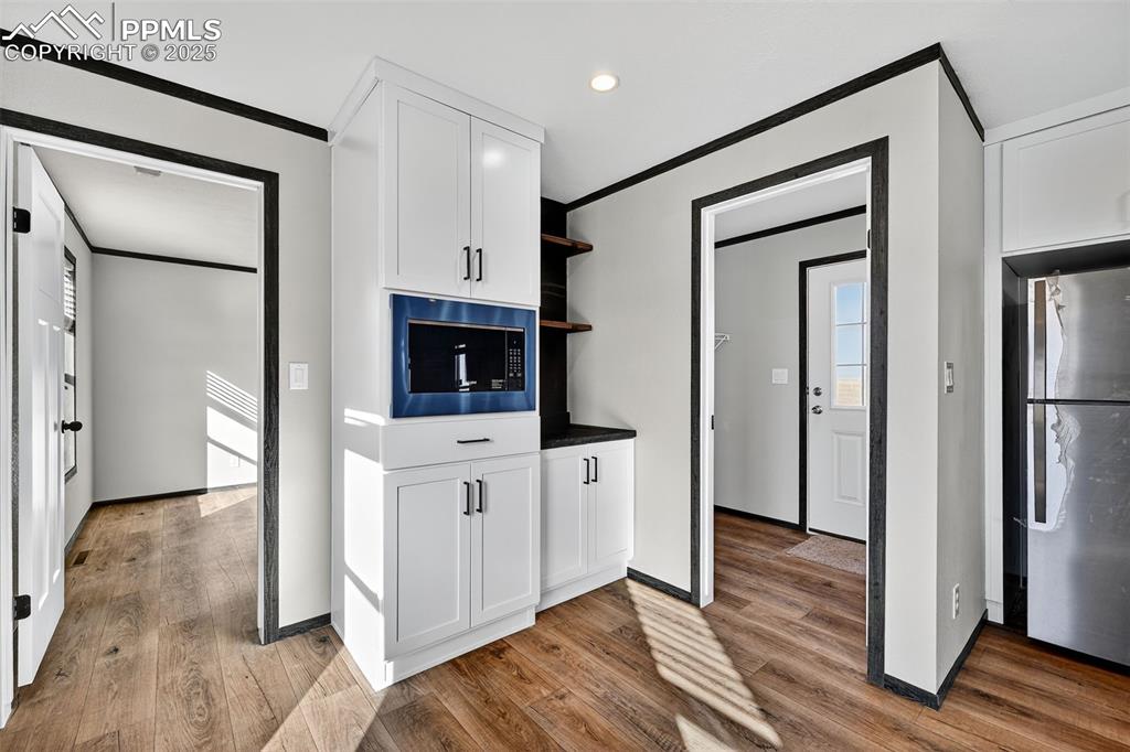 6815 Ramah Highway Yoder, CO 80864 - Photo 14 of 39 a kitchen with white cabinets and stainless steel appliances