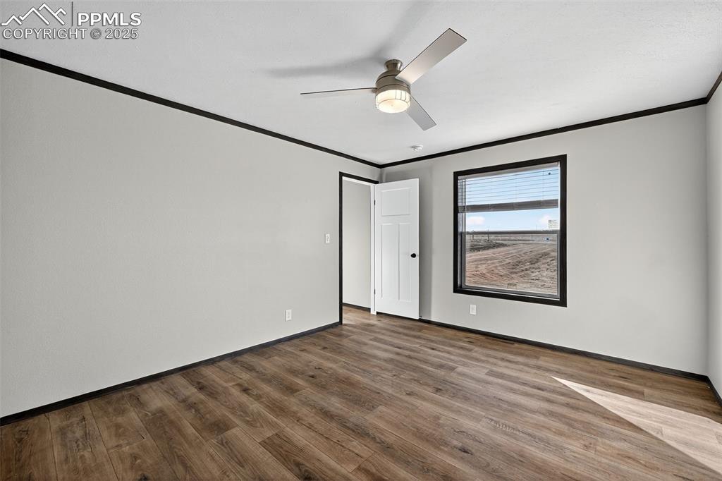 6815 Ramah Highway Yoder, CO 80864 - Photo 16 of 39 an empty room with wooden floor and fan