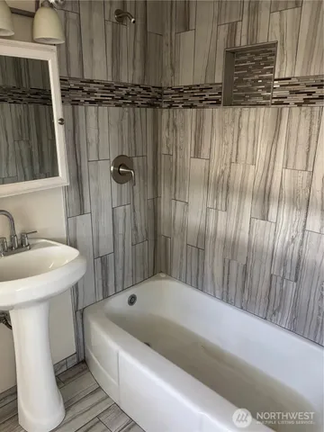 a bathroom with a sink a window and a shower