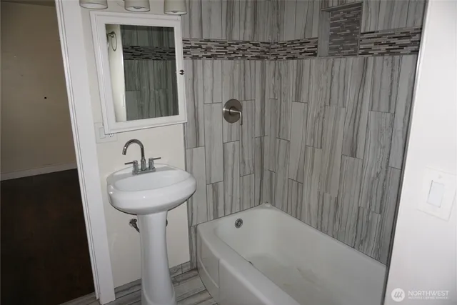 a bathroom with a sink a bathtub and shower
