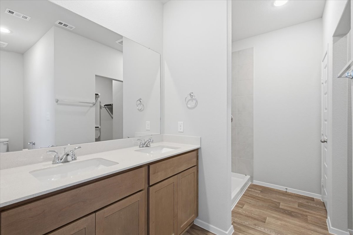 2714 Foss Road Manor, TX 78653 - Photo 18 of 34 Clean lines and a spacious dual vanity define this modern bathroom with wood-look flooring.