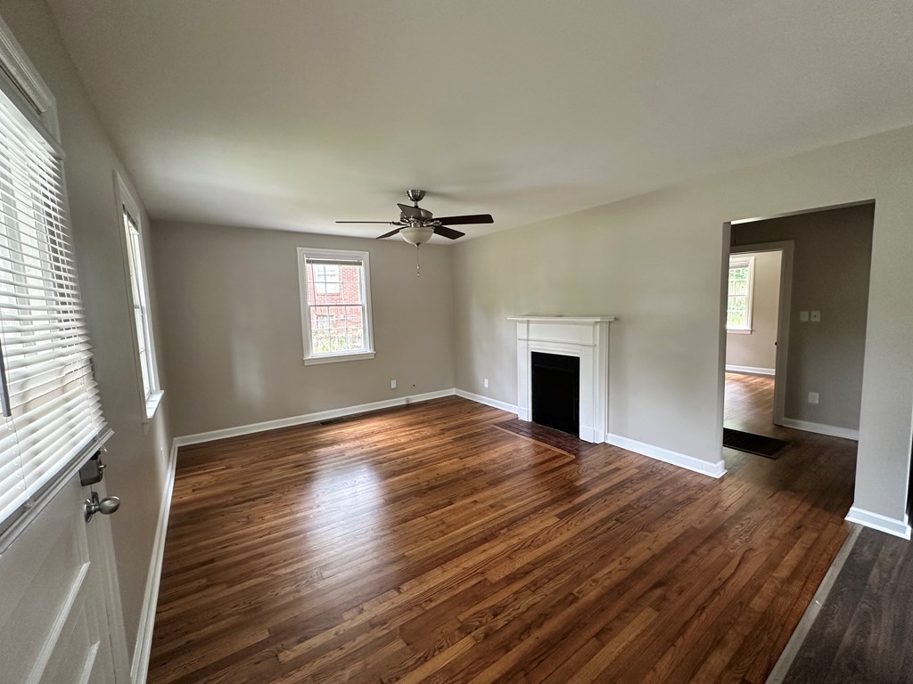 3136 Norris Road Columbus, GA 31907 - Photo 12 of 17 an empty room with wooden floor fireplace and windows