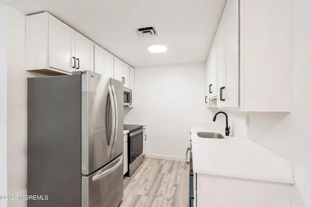 a kitchen with stainless steel appliances a refrigerator and a sink