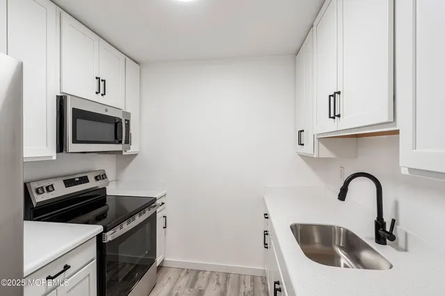 a kitchen with stainless steel appliances a sink a stove and microwave