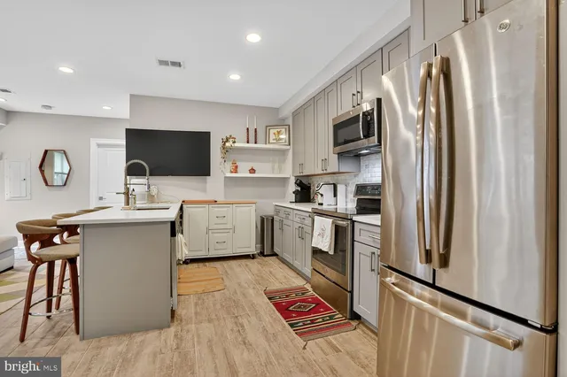 a kitchen with stainless steel appliances a refrigerator microwave and sink
