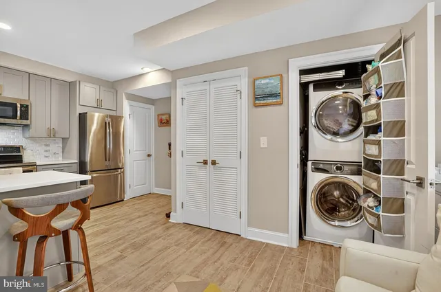 a view of a kitchen with refrigerator and wooden floor