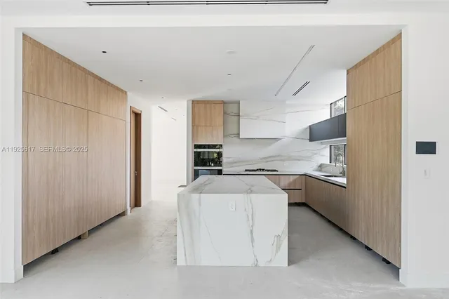 a kitchen with stainless steel appliances granite countertop a refrigerator a sink dishwasher a stove and white countertops with wooden floor