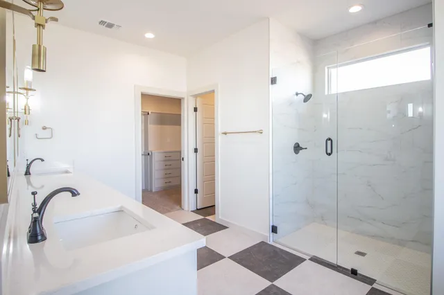 a bathroom with a tub shower vanity and a sink