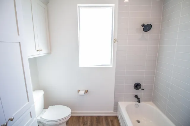 a view of empty room with floor to ceiling window and wooden floor