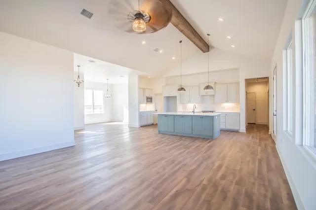 a large kitchen with lots of counter space a sink stainless steel appliances and cabinets