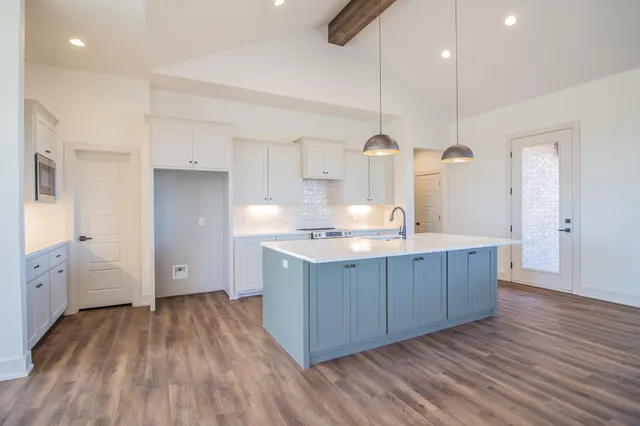 a view of a kitchen with wooden floor and cabinets