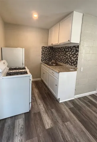 a kitchen with granite countertop a stove and cabinets